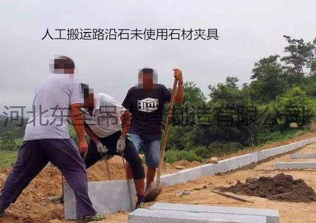 未使用雙人抬石頭的夾子作業現場，兩人使用鋼絲繩費力搬運路沿石--河北東圣吊索具制造有限公司--石材夾具|小型攪拌機|液壓堆高車|手動叉車